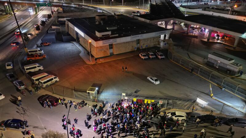 People take part in a vigil for the victims of a fire at an immigration detention center that...