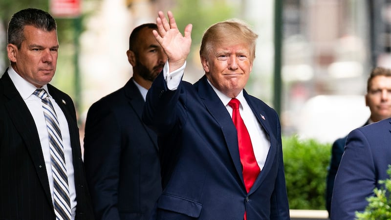 Former President Donald Trump waves as he departs Trump Tower, Wednesday, Aug. 10, 2022, in...
