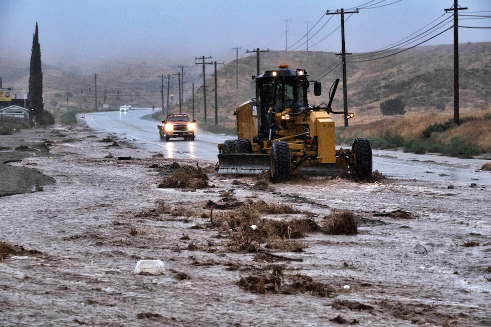 A plow clears debris along a flooded Sierra Highway in Palmdale, Calif., as Tropical Storm...