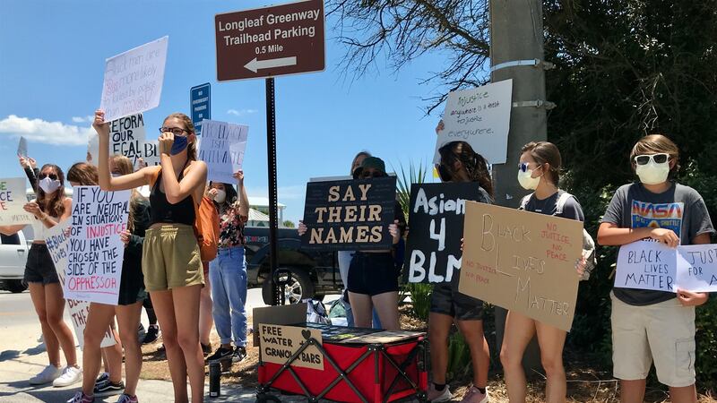 Teenagers accompanied by some adults gathered in Santa Rosa Beach Sunday afternoon to protest...