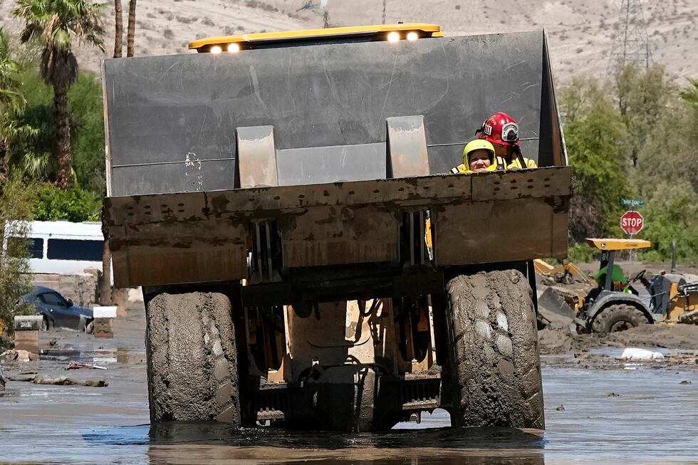Firefighters use a skip loader to rescue a person from an assisted living center after the...