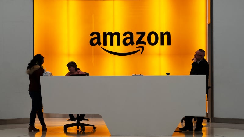 In this Feb. 14, 2019 file photo, people stand in the lobby for Amazon offices in New York....