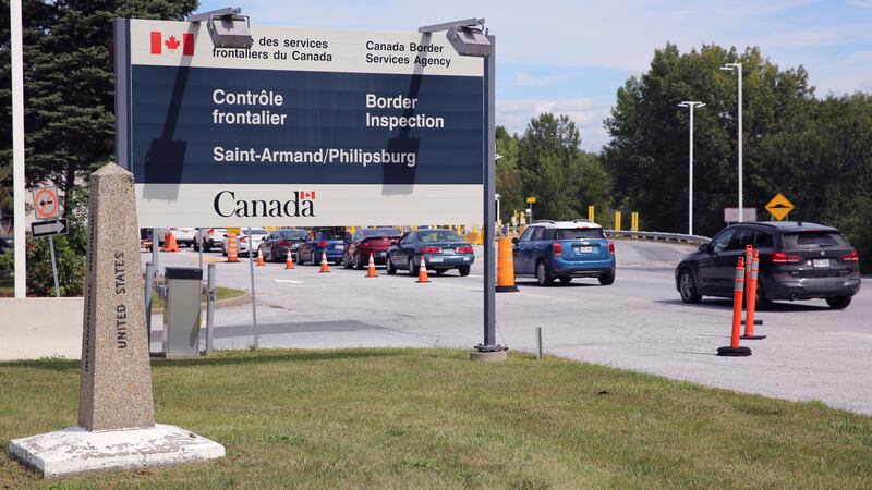 Cars pass a monument marking the border between the United States and Canada on Wednesday,...
