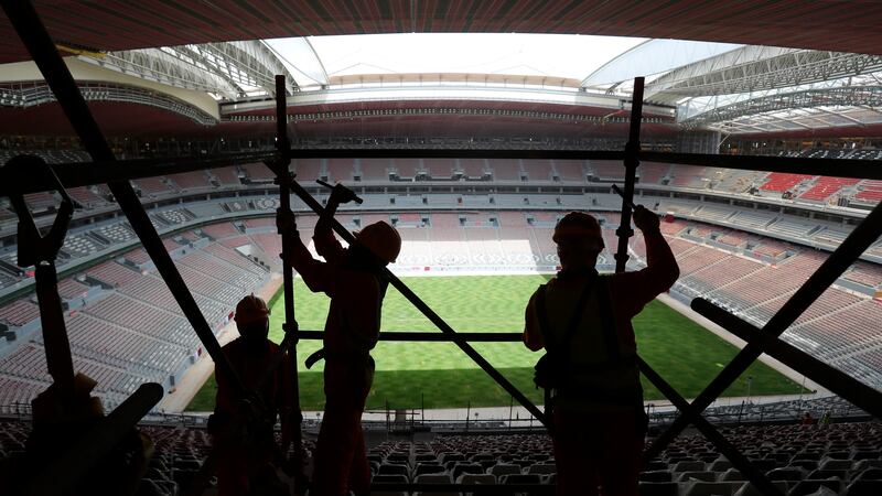 FILE - Laborers remove scaffolding at the Al Bayt stadium in Al Khor, Qatar, about 50...